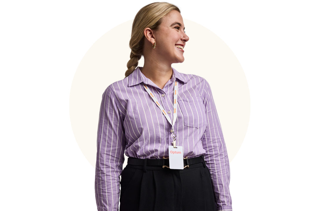 Professional standing and wearing an Optum badge against a neutral background 